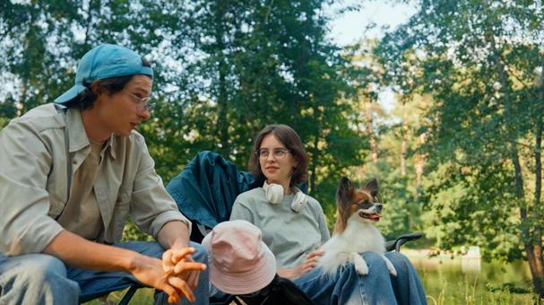 森の中でリラックスする男女 男女,外国人,犬の写真素材