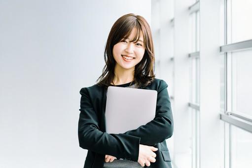 パソコンを持つ女性・ビジネスウーマン パソコンを持つ女性・ビジネスウーマン 女性,パソコン,笑顔の写真素材