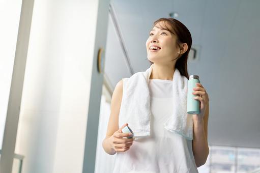 スポーツジムで水分補給する女性 スポーツジム,水分補給,女性の写真素材