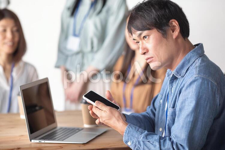 服装自由な会社でスマホを使う会社員 スマホ,ビジネス,スマートフォンの写真素材