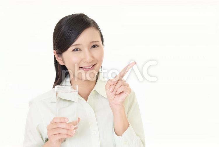 お水の入ったグラスを持つ笑顔の女性 女性,女,笑顔の写真素材