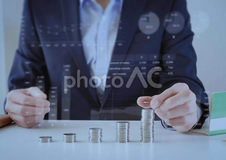 コインを重ねるビジネスマンとグラフ背景 お金,運用,成功の写真素材