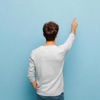 シンプル背景で方向を示す男性の後ろ姿 シンプル背景で方向を示す男性の後ろ姿の写真