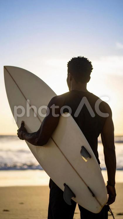 サーフボードを抱えた人物のシルエット サーフボード,ボード,シルエットの写真素材