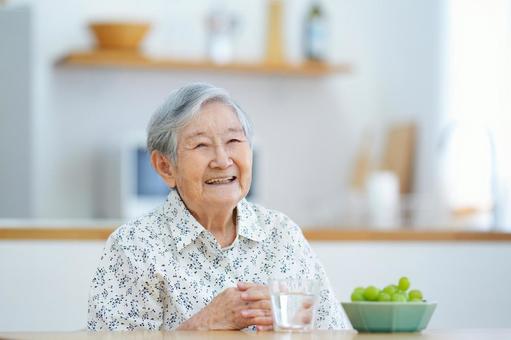 手を組み笑う高齢女性 女性,笑顔,座るの写真素材