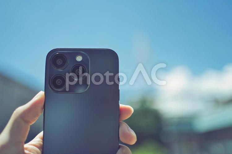 青空とスマホを持つ人の手 スマホ,スマートフォン,スマートホンの写真素材