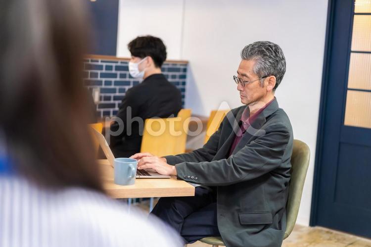 カフェで仕事をする中年男性 カフェ,テレワーク,リモートワークの写真素材