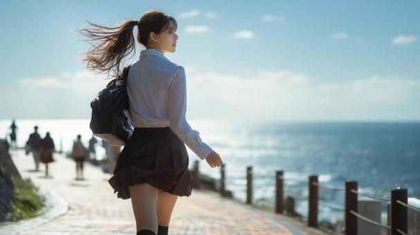 海沿いの歩道を走る女学生 海沿いの歩道を走る女学生の写真