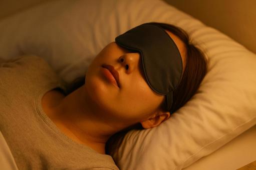 アイマスクをして眠る女性 アイマスクをして眠る女性の写真