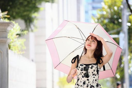 日傘をさして舗道を歩く女性 日傘をさして舗道を歩く女性 女性,美人,日傘の写真素材