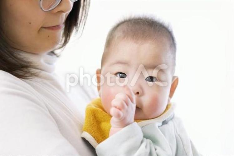 抱っこされて指をしゃぶるアジア人の赤ちゃん	 赤ちゃん,咥える,おしゃぶりの写真素材