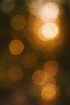 暖かいオレンジ色の玉ボケの優しい輝きの写真