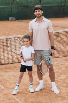 コートに立つ親子のテニス風景 親子,女の子,外国人の写真素材