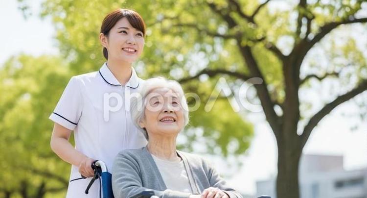 屋外で散歩をする看護師と車椅子の患者 看護師,患者,女性の写真素材