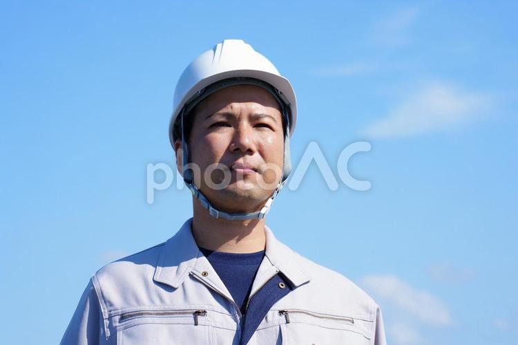 青空背景の作業服の男性 男性,日本人,アジア人の写真素材