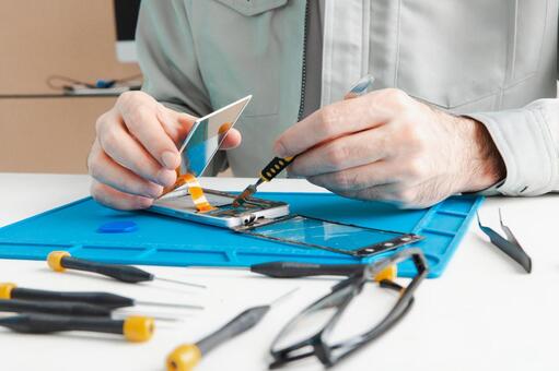 ヘラを使いスマホの画面を分解する手元 スマートフォン,修理,画面の写真素材