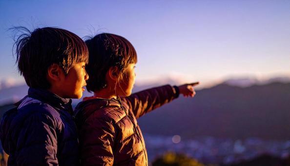 夕焼けの空を見つめる日本人の少年 夕焼けの空を見つめる日本人の少年の写真
