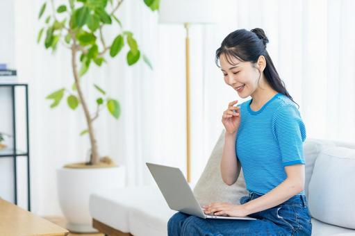 パソコンを操作する女性 女性,笑顔,ノートパソコンの写真素材