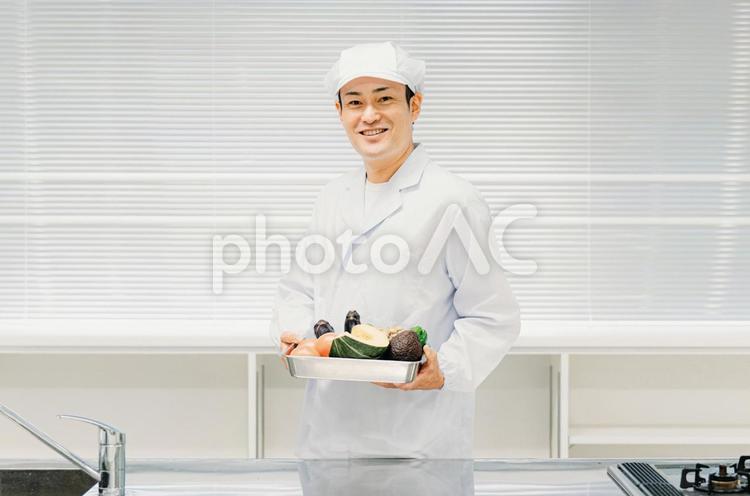 調理服を着た野菜を持つ男性（食品工場） 調理師,シェフ,料理人の写真素材