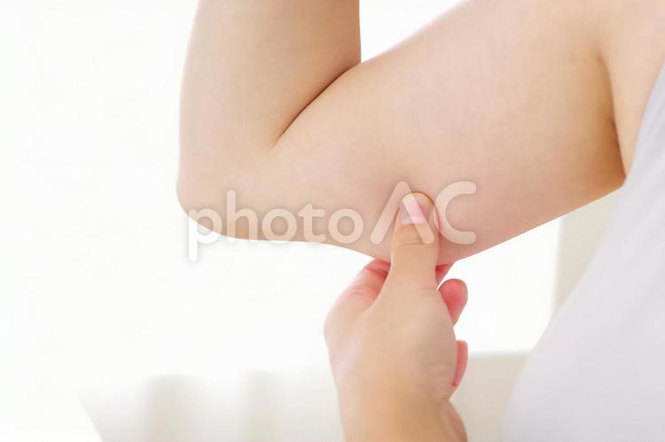 二の腕をつまむ若い女性 二の腕,腕,たるみの写真素材