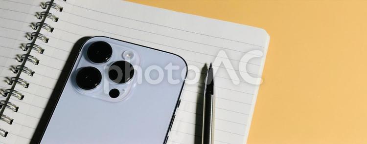 デスクの上のリングノートとスマホ　バナー ビジネスイメージ,バナー素材,ビジネスアイテムの写真素材