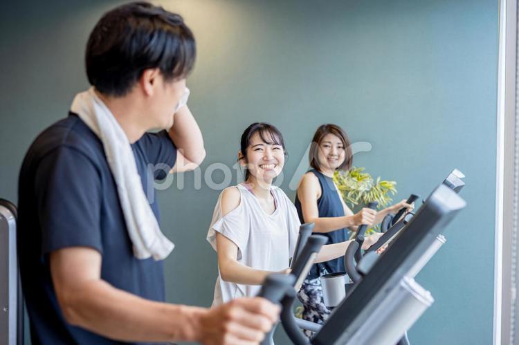 スポーツジムで運動する男女（笑顔） スポーツジム,有酸素運動,運動の写真素材