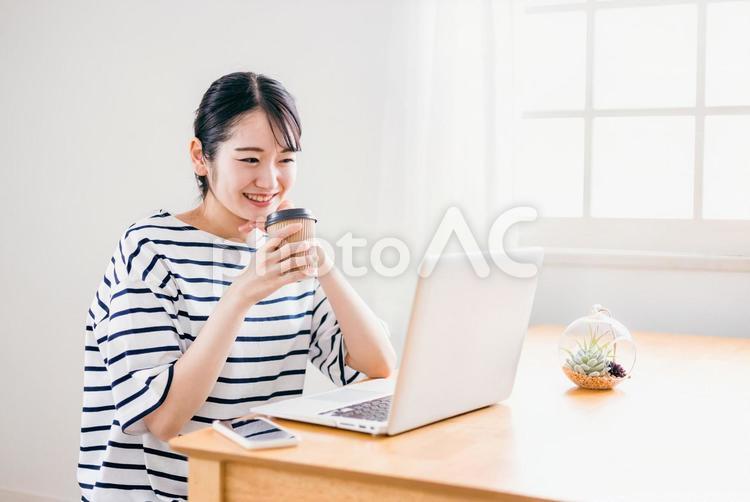 コーヒーを飲みながらテレワークする女性 コーヒー,パソコン,映画の写真素材