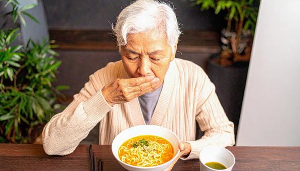 食事中、歯が痛む高齢者女性 食事中、歯が痛む高齢者女性の写真