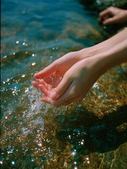 夏の日の水辺で遊ぶ手と透明な水 夏の日の水辺で遊ぶ手と透明な水の写真