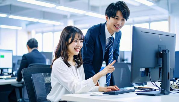 パソコンを見ながら打ち合わせをする社員 パソコンを見ながら打ち合わせをする社員の写真