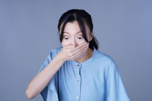 口を手で覆って驚く青い服の女性 女性,驚く,口を覆うの写真素材