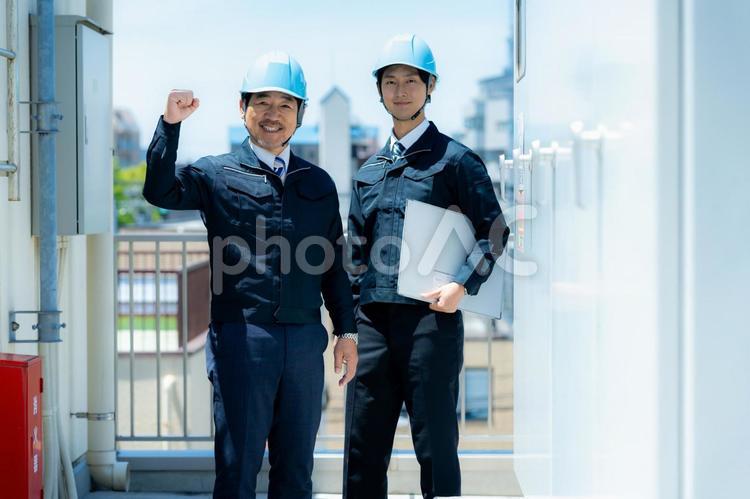 現場で打ち合わせする作業服のビジネスマン 現場で打ち合わせする作業服のビジネスマン 作業服,笑顔,打ち合わせの写真素材