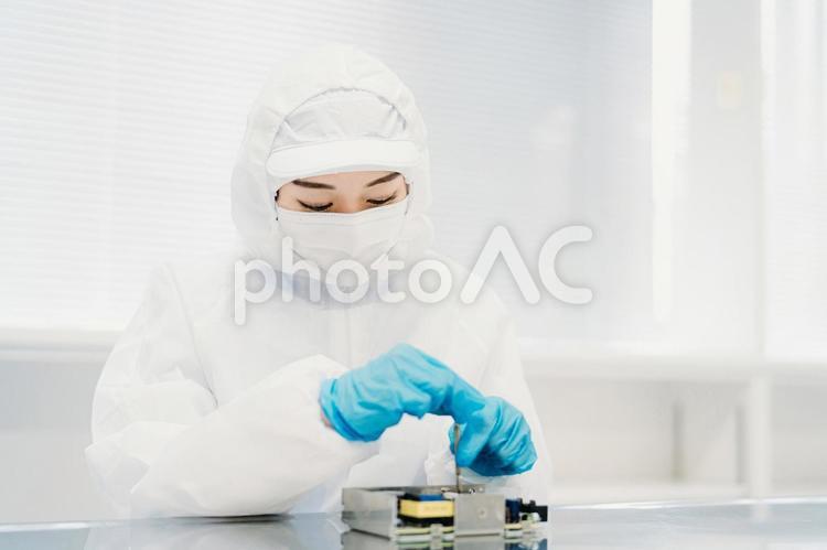 クリーンルームで精密機器を扱う女性 工場,製造業,精密機器の写真素材