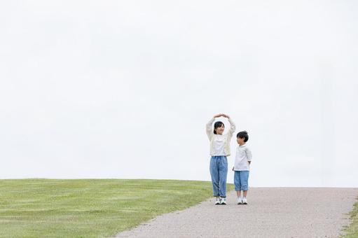 丘の上を笑顔で歩く子ども 丘の上を笑顔で歩く子ども 子ども,笑顔,歩くの写真素材