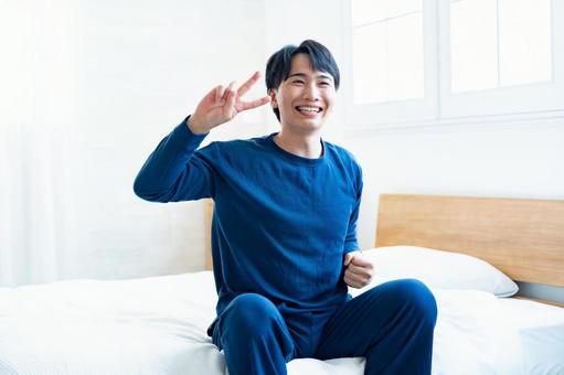 ベッドで笑顔の男性 ベッドで笑顔の男性 アジア人,家,室内の写真素材