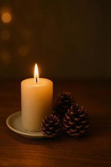 キャンドルと松かさの写真