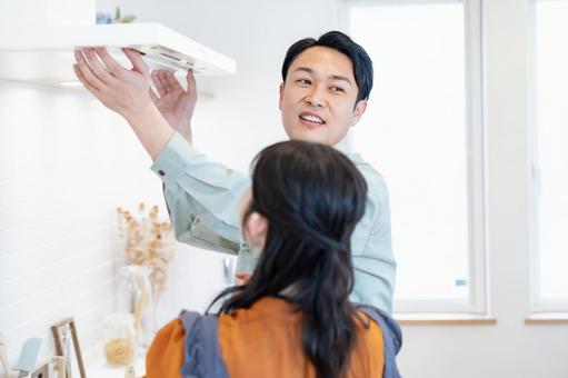 業者にキッチンの換気扇をみてもらう主婦 業者にキッチンの換気扇をみてもらう主婦 リノベーション,換気扇,メンテナンスの写真素材