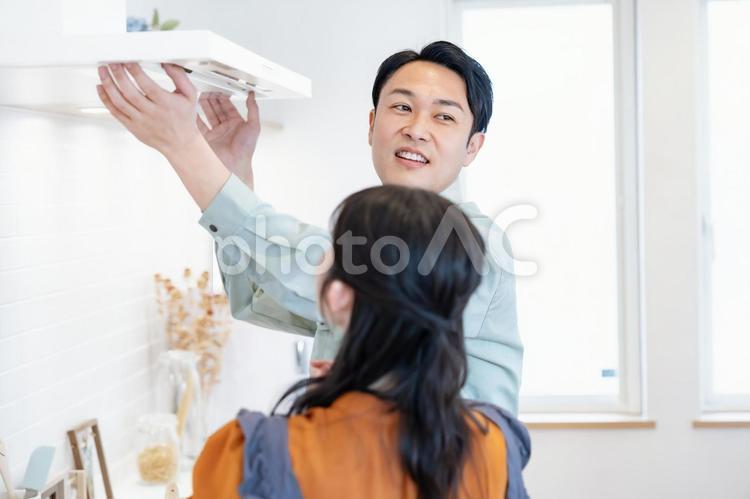業者にキッチンの換気扇をみてもらう主婦 リノベーション,換気扇,メンテナンスの写真素材