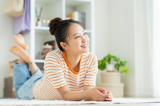 リビングでくつろぐ若い女性 リビングでくつろぐ若い女性の写真
