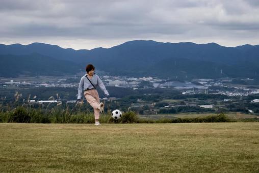 ＜素材＞山頂で元気にサッカーをする女性 女性,サッカー,運動の写真素材