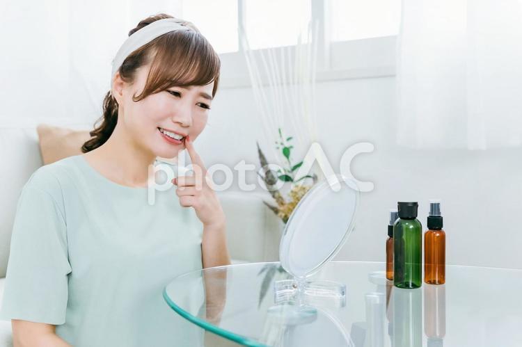 家で鏡を見ながら奥歯・口内炎で悩む女性 奥歯,親知らず,虫歯の写真素材