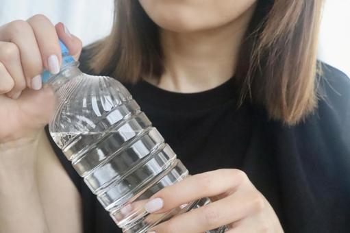 ペットボトルを持つ女性 ペットボトルを持つ女性の写真