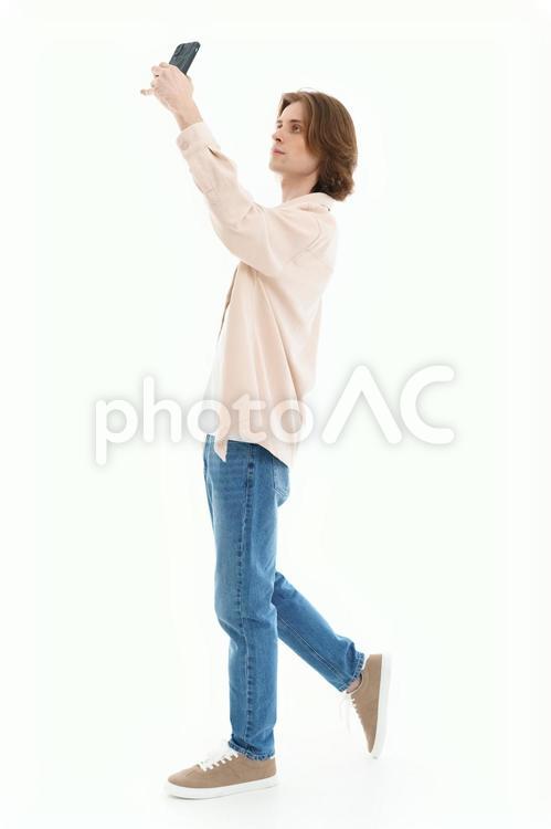スマホで自撮りする横向き男性 男性,スマートフォン,持つの写真素材