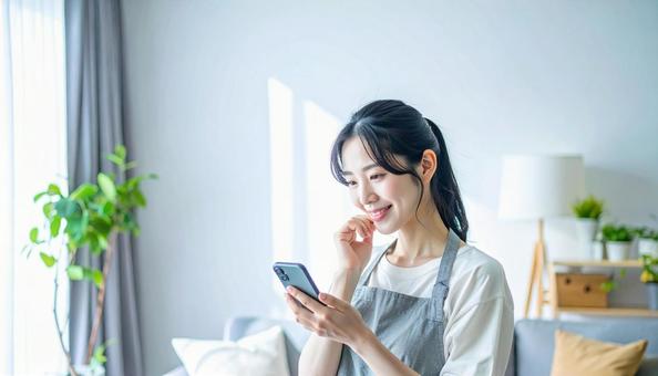 スマホでポイ活する笑顔の女性の写真