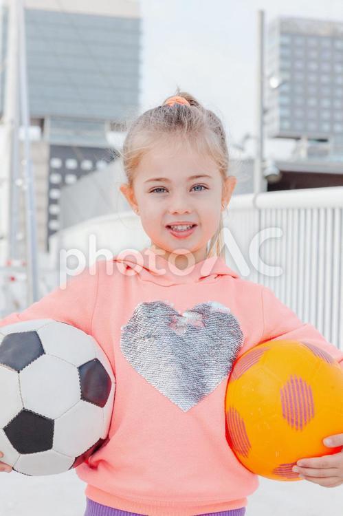 両手でボールを抱えて持つ女の子 女の子,ボール,サッカーボールの写真素材