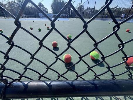 フェンス越しのテニスコートと練習ボール テニス,テニスコート,スポーツの写真素材