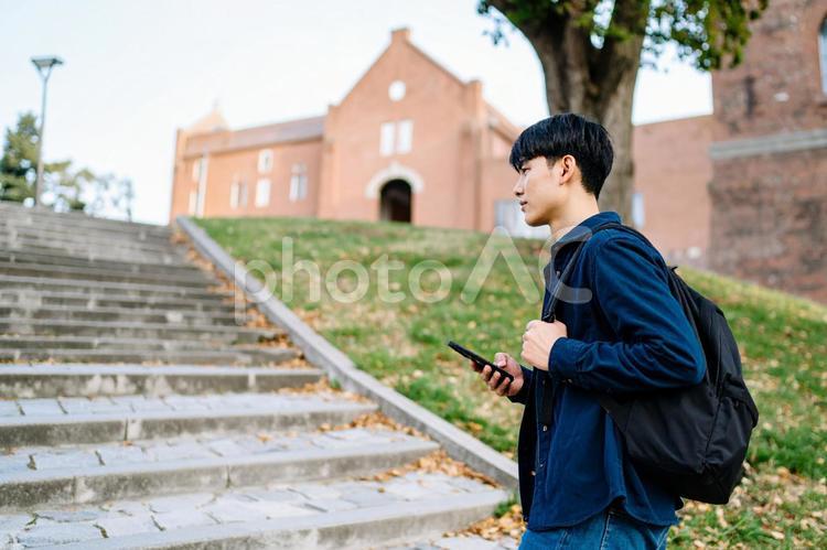大学の構内を歩く男子大学生 日本人,男性,人物の写真素材