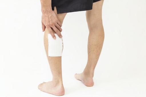 湿布を貼った男性の脚 白バック 湿布を貼った男性の脚 白バック 男性,脚,足の写真素材