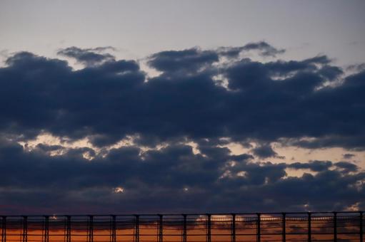 夕暮れの雲とフェンスのシルエット 夕暮れの雲とフェンスのシルエット 夕暮れ,雲,空の写真素材