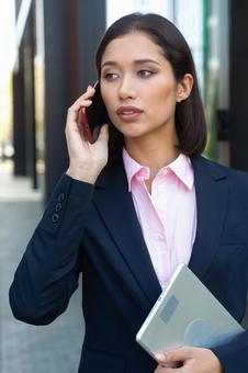 アジア人ビジネスウーマンがオフィス街で電話している ビジネスウーマン,ビジネス,女性の写真素材